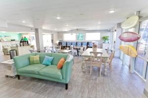 彭萨科拉海滩冲浪和沙滩酒店的客厅配有绿色沙发和桌子