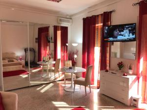 马利耶B&B del Benessere Beauty & Welness的客厅配有电视和桌椅