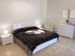 马利耶B&B del Benessere Beauty & Welness的一间卧室配有带枕头的床和2个床头柜