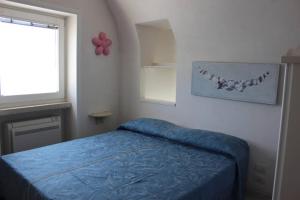 拉维罗La Torre的一间卧室配有一张带蓝色床罩的床和窗户。