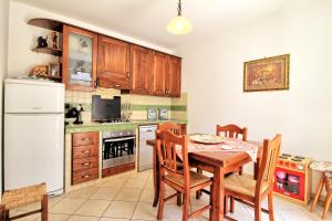莱乌卡Villetta Ada的厨房配有桌子和白色冰箱。