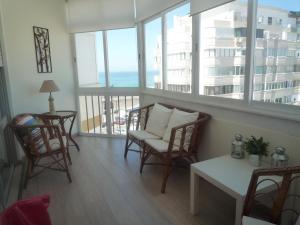 卡帕里卡海岸Casa Mar的客厅配有椅子和桌子,设有窗户