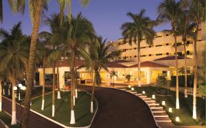 圣克鲁斯华特库瓦图尔科水疗梦幻度假酒店的一座楼前有棕榈树的酒店