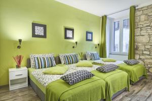 普拉市中心旅馆的一间卧室配有两张带绿床单和枕头的床。