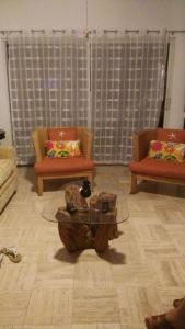 阿卡普尔科Mayan Vidanta Villas GOLF a 800 mt de la playa的客厅配有两把椅子和一张茶几