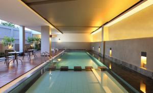 明古鲁省桑蒂卡明古鲁酒店的大楼内带桌椅的游泳池