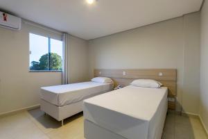 大坎普WR Confort Hotel Campo Grande的小型客房 - 带2张床和窗户