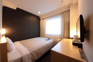 东京日本亚洲会馆酒店 的配有一张床、一张书桌和一扇窗户的酒店客房