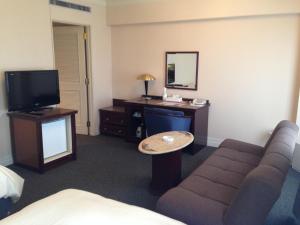 磐城克莱斯顿酒店的一间配有沙发、一张桌子和一台电视的酒店客房