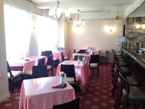磐城克莱斯顿酒店的用餐室配有桌椅和粉红色的桌布
