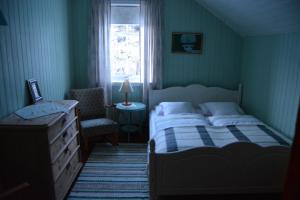 Bø i VesterålenSkagakaia的卧室配有床、椅子和窗户。