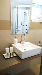 斯利亚奇格林别墅酒店的浴室设有白色水槽和镜子