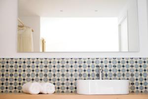 休达德亚Agroturismo Ses Talaies的一间带水槽和瓷砖墙的浴室