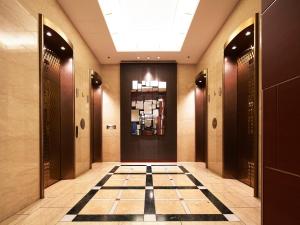 大阪大阪新阪急酒店的走廊上设有门,铺有瓷砖地板