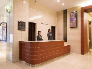 大阪大阪新阪急酒店的站在柜台上的男女