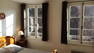 斯特拉斯堡Les appartements Place de la Cathédrale的一间卧室设有2扇窗户和1张床铺