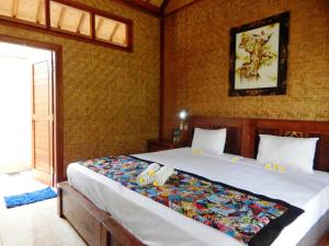 班尤温当托克孟赞甘酒店的卧室配有一张白色大床