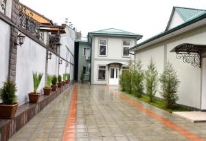 塔什干克拉特酒店的一座空旷的庭院,里面种有盆栽植物,还有一座白色的建筑