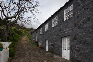 ManadasCasa do Zé - AL的石屋,有白色的窗户和土路