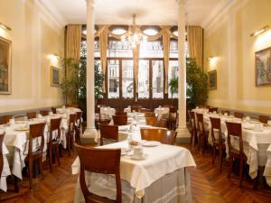 威尼斯圣塔罗酒店的一间带桌椅和吊灯的餐厅