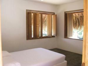 帕洛米诺Casa Carey的一间带2张白色床和2扇窗户的卧室