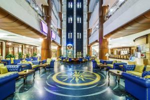 迪拜柏迪拜怡东大酒店的大楼内带蓝色桌椅的大堂