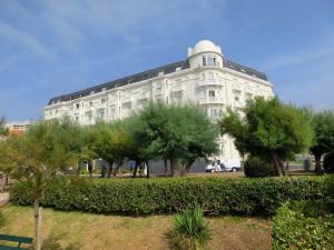 比亚里茨Apartment Golf Beach Régina Biarritz的前面有树木的白色大建筑