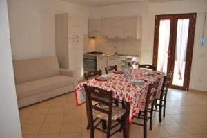 坎波内莱尔巴Appartamenti Margherita的一间带桌椅的用餐室和一间厨房