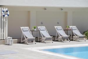 斯科派洛斯Skopelos Village Hotel的连排躺椅和一个游泳池