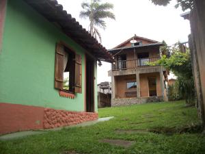 拉夫拉斯诺瓦斯Pousada Beija-Flor的一座绿色建筑,背后是棕榈树
