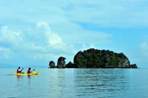 丹绒鲁唐君鲁度假村的两人在水中乘坐黄色皮艇,在岛上