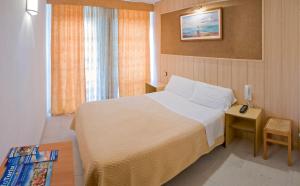 萨洛Pensión Venecia的一间卧室配有一张床和一张桌子及床头柜