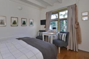 DreischorHerberg De Ring的一间卧室配有一张床、一张书桌和一个窗户。