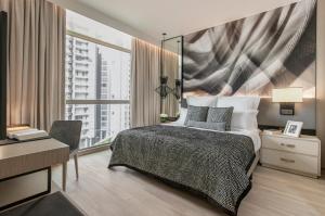 新加坡Ascott Orchard Singapore的一间卧室配有一张床、一张书桌和一个窗户。