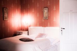 史特林史特林威斯尼斯酒店的卧室配有一张白色大床和红色壁纸