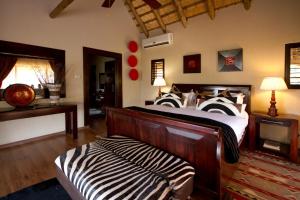 纳姆比提动物保护区Umzolozolo Private Safari Lodge & Spa的一间卧室,卧室内配有斑马印花床