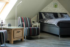 坎珀兰Hoeve Hofwijk的一间卧室配有一张床、一把椅子和一张桌子