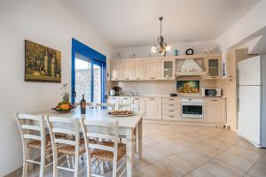 拉多斯Maripaul Family Villa的厨房配有桌椅和冰箱。