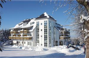 库罗阿尔滕堡组姆贝尔拉酒店的一座白色的大建筑,四周积雪