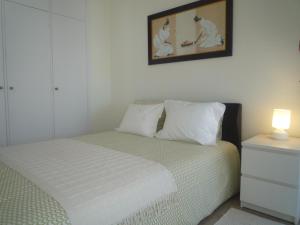 卡帕里卡海岸Casa Mar的一间卧室配有一张带灯的床,墙上挂着一张照片