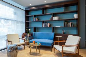 巴黎Hôtel Sanso by HappyCulture的客厅配有蓝色的沙发和椅子