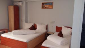加拉茨Hotel Corneliuss的小房间设有两张带白色床单的床