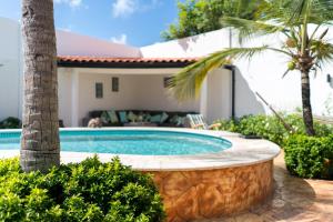 棕榈滩Cas Elizabeth的一座棕榈树和房子的游泳池