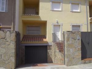 特鲁希略Apartamento Villa Soterraña的一座建筑,设有两个车库门和石墙