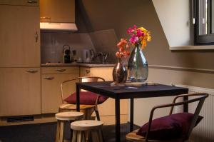 乌登让邦酒店的厨房配有一张桌子,上面放着花瓶