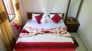 本托塔卡维民宿的一间卧室配有红色和白色床单