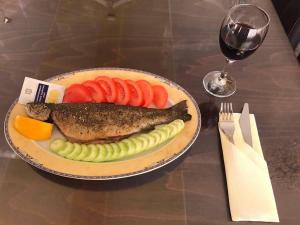 多斯帕特Hotel Kristal的一小盘鱼和蔬菜,一杯葡萄酒