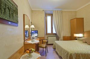 罗马博物馆酒店的酒店客房设有一张床和一张带一碗水果的书桌