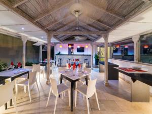 卡塔赫纳萨尔梅迪纳酒店的一间带桌子和白色椅子的用餐室
