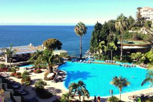 丰沙尔Pestana Madeira Beach Club的一个大型的游泳池,背景是大海